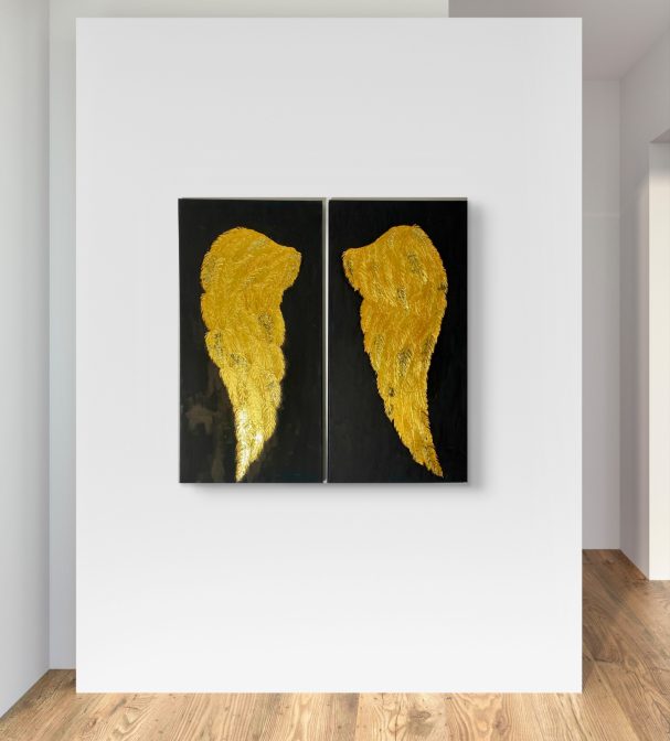 Zwei goldene Engelsflügeln auf schwarzem Hintergrund.